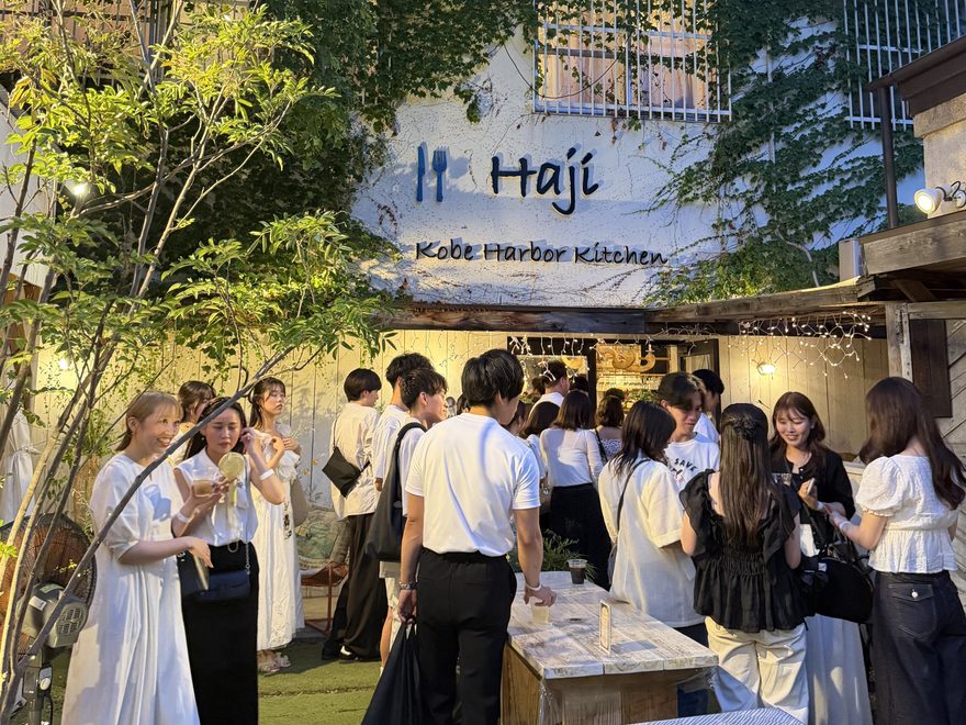 屋外会場での立食パーティーで歓談する参加者